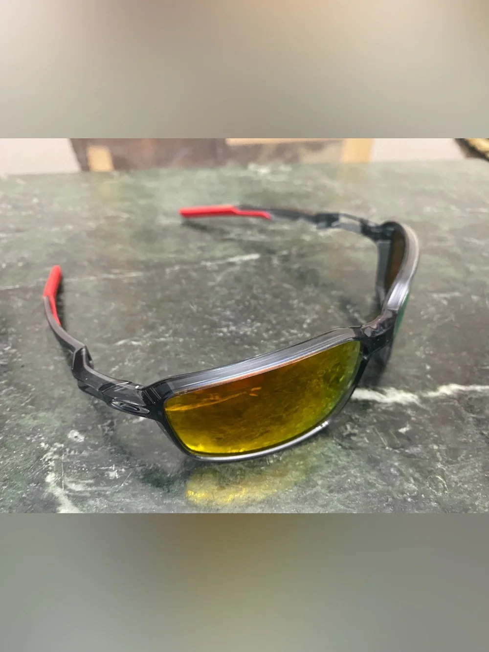Oakley Siphon featuring a translucent crystal frame with vibrant red ear socks.